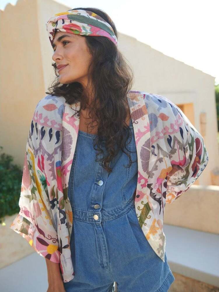 Are kimonos in style​? Woman wearing a multi-coloured One Hundred Stars Kimono and headband with a denim playsuit.