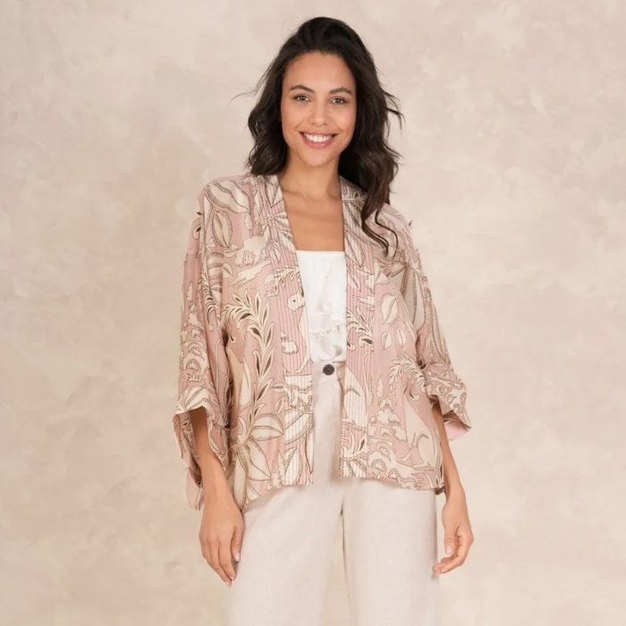 How to dress up a kimono​. Woman wearing a pink One Hundred Stars kimono with a white cami top and cream trousers. 