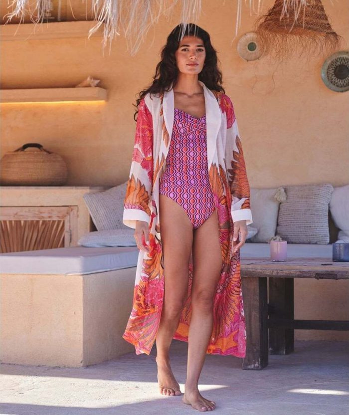 How to style a kimono robe. Woman wearing a pink and orange One Hundred Stars kimono robe with a pink swimming costume. 