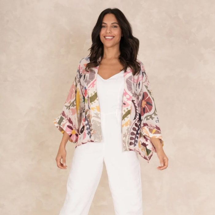 How to wear a fashion kimono​. Woman wearing a multi-coloured kimono with a plain white jumpsuit.