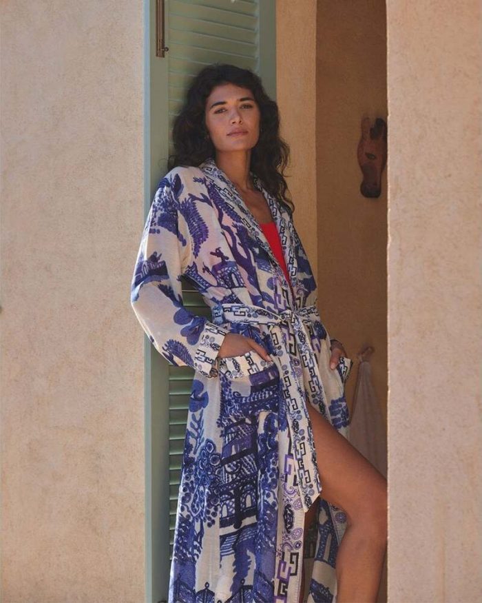 Can you wear accessories with a kimono​? Woman wearing a blue and white One Hundred Stars kimono robe with a sash belt.