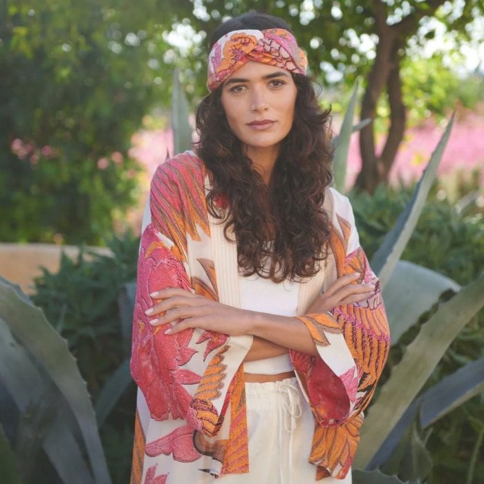 Can you wear accessories with a kimono​? Woman wearing a pink and orange One Hundred Stars kimono with matching headband.